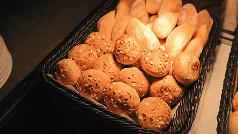 Different-kinds-of-mini-bread-rolls-are-displayed-in-warm-light