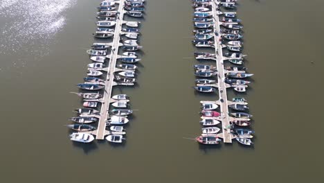 Drone-view-of-Cais-do-Bico-boat-deck,-serene-water-in-Murtosa,-Aveiro,-Portugal