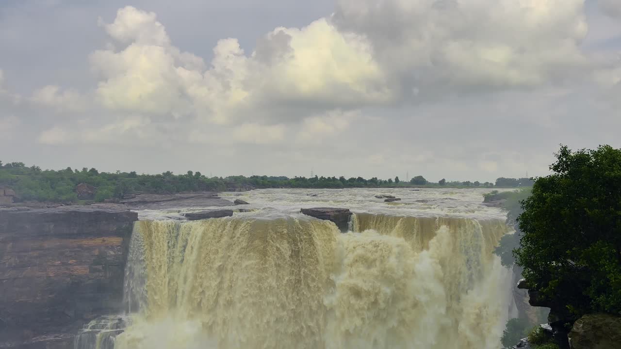The image depicts a breathtaking waterfall, with water cascading down a rocky cliffside