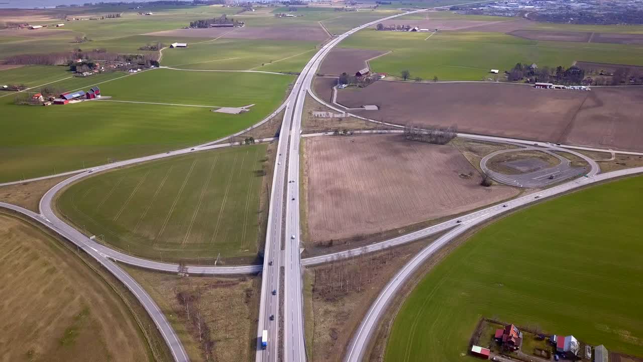 Aerial view of freeway intersection with moving traffic cars.