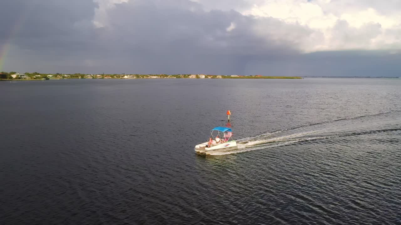 vista aérea alrededor de un barco con un arco iris en el fondo, en florida - órbita, disparo de drones