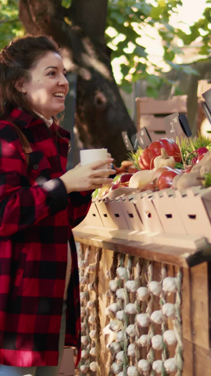 Vídeo vertical: clienta y proveedor bebiendo una taza de café caliente en un mercado agrícola
