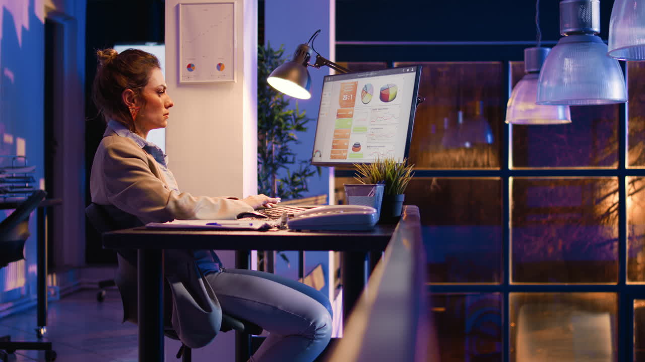 Donna che lavora al computer in ufficio di notte