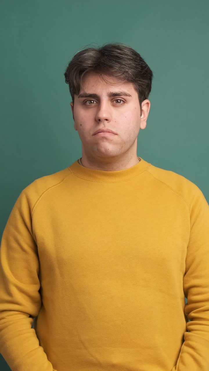 Serious young man looking at camera standing hands on pocket