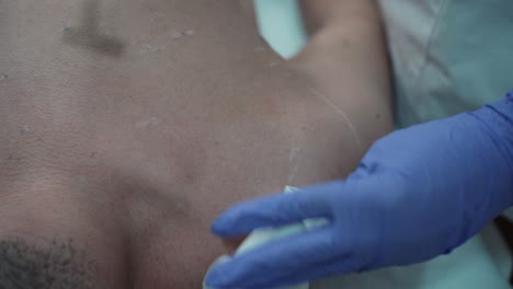 técnica de depilación con afeitadora en el hombro del hombre