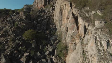 aerial view of a rugged mountainside with a steep cliff face and a landslide