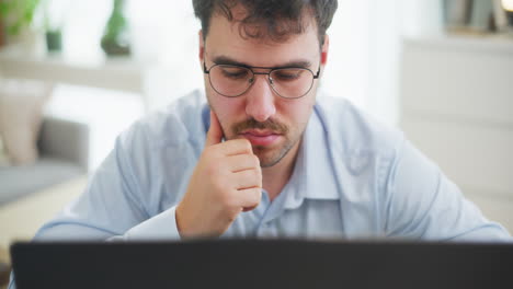 primer plano de un hombre leyendo una investigación en una computadora portátil