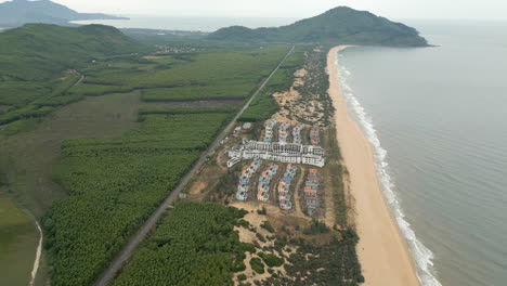 Drone-Tracks-Back-Over-Lang-Co-Beach-With-Deserted-Hotel-Complex-Below