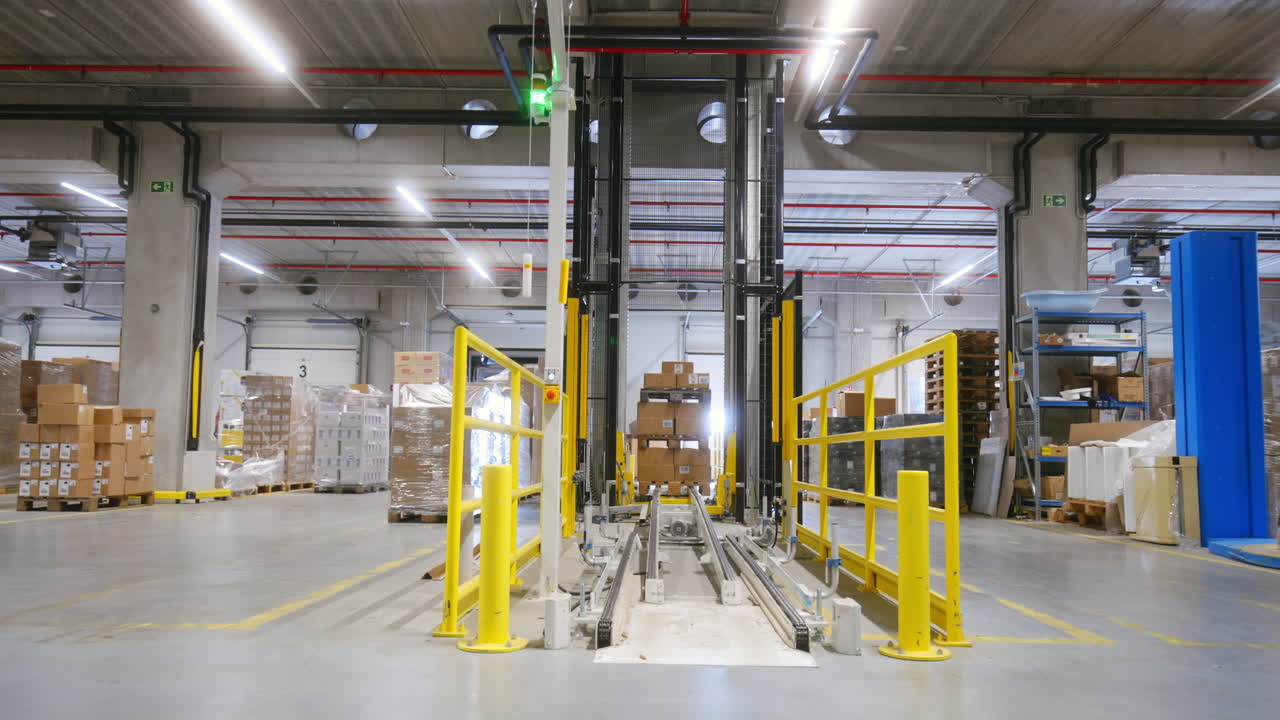 Autonomous lift operates in a logistics warehouse as it loads and unloads goods at various times during the day