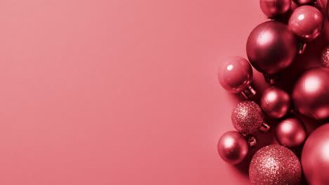 video of red baubles christmas decorations with copy space on red background