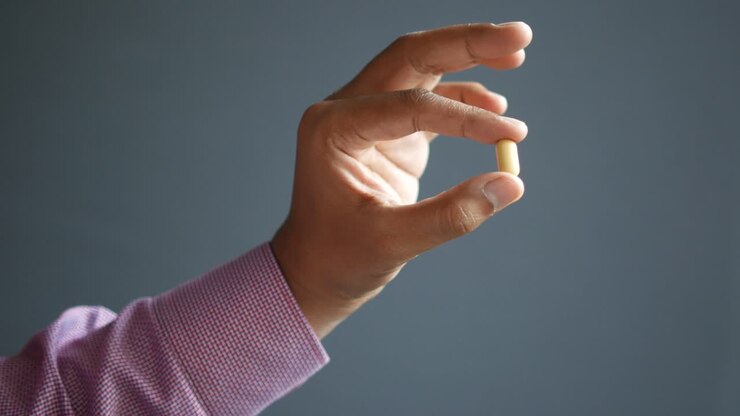 La mano che tiene una pillola