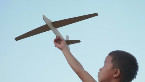 boy playing with a paper airplane