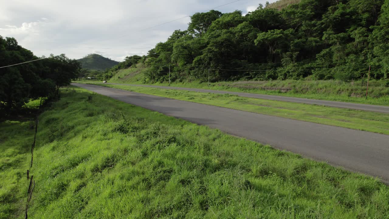 Empty rural asphalt road surrounded by lush green nature near Río Verde, Venezuela