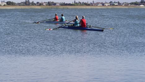 four senior caucasian men and women rowing boat on a river