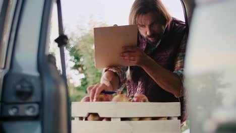 Slow motion of farmer checking some data from the clipboard