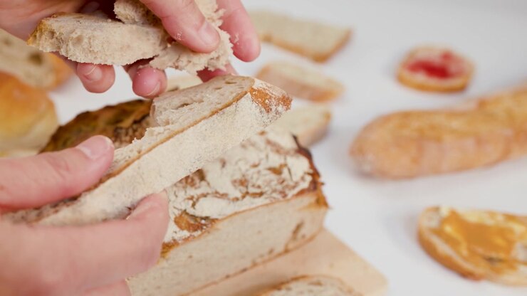 Hands Tearing a Slice of Fresh Sourdough Bread