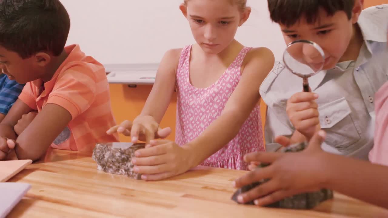 escolares examinando roca en el laboratorio