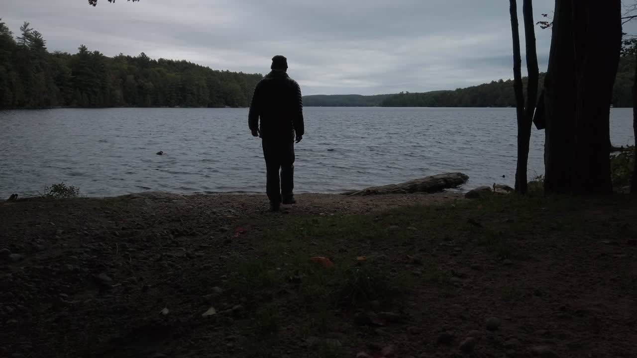 프레임에 들어가 맥도날드 호수 기슭에 도착하는 사람의 와이드 샷