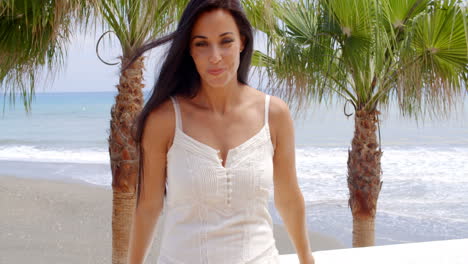 Mujer-Vestida-De-Blanco-Parada-En-Una-Playa-Tropical