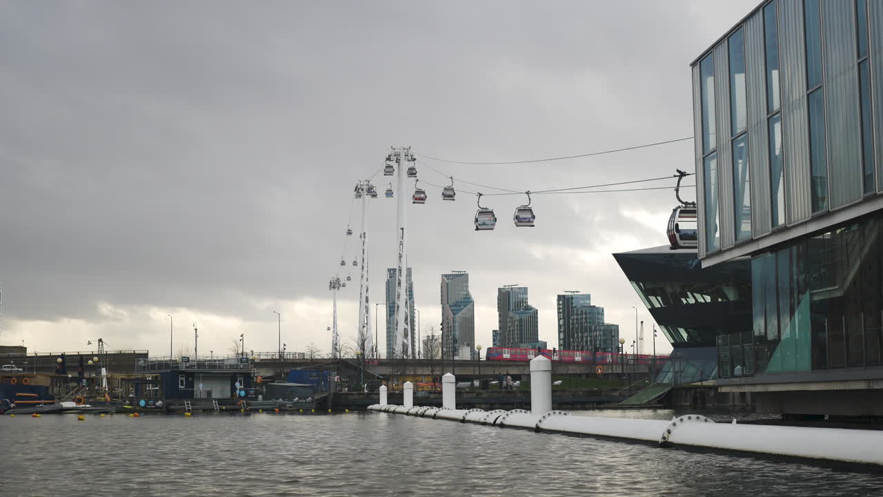 Wide shot of cable cars crossing the River Thames on a cloudy day London UK