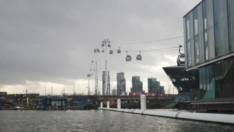 wide shot of cable cars crossing the river thames on a cloudy day london uk