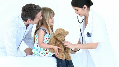 doctor escuchando a un oso de peluche con un estetoscopio