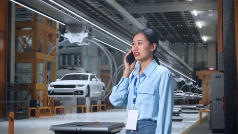 woman talking on phone in a modern car factory