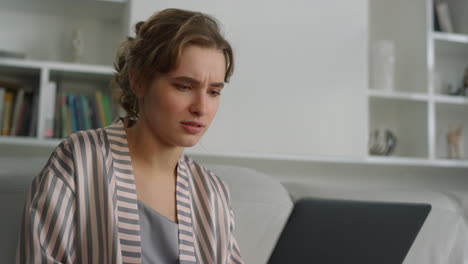 Closeup-relaxed-girl-videocalling-in-pajamas.-Smiling-woman-using-laptop-resting