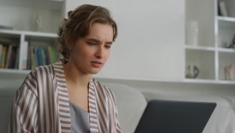 closeup relaxed girl videocalling in pajamas. smiling woman using laptop resting