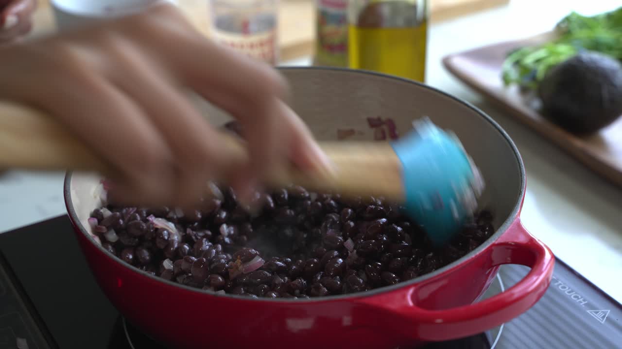 mezclar una olla de frijoles negros y mezclarlo en una olla de hierro fundido dos latas de frijolas arroz plátano aguacate cebolla roja y cilantro