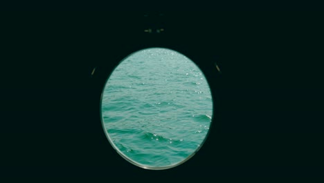 A-cruise-ship's-porthole-overlooking-the-open-ocean-and-horizon