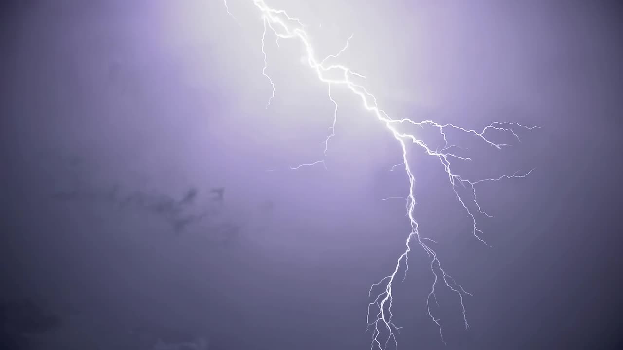 Video time-lapse drammatico di fulmini che illuminano nuvole temporalesche scure, catturato da un'angolazione bassa.