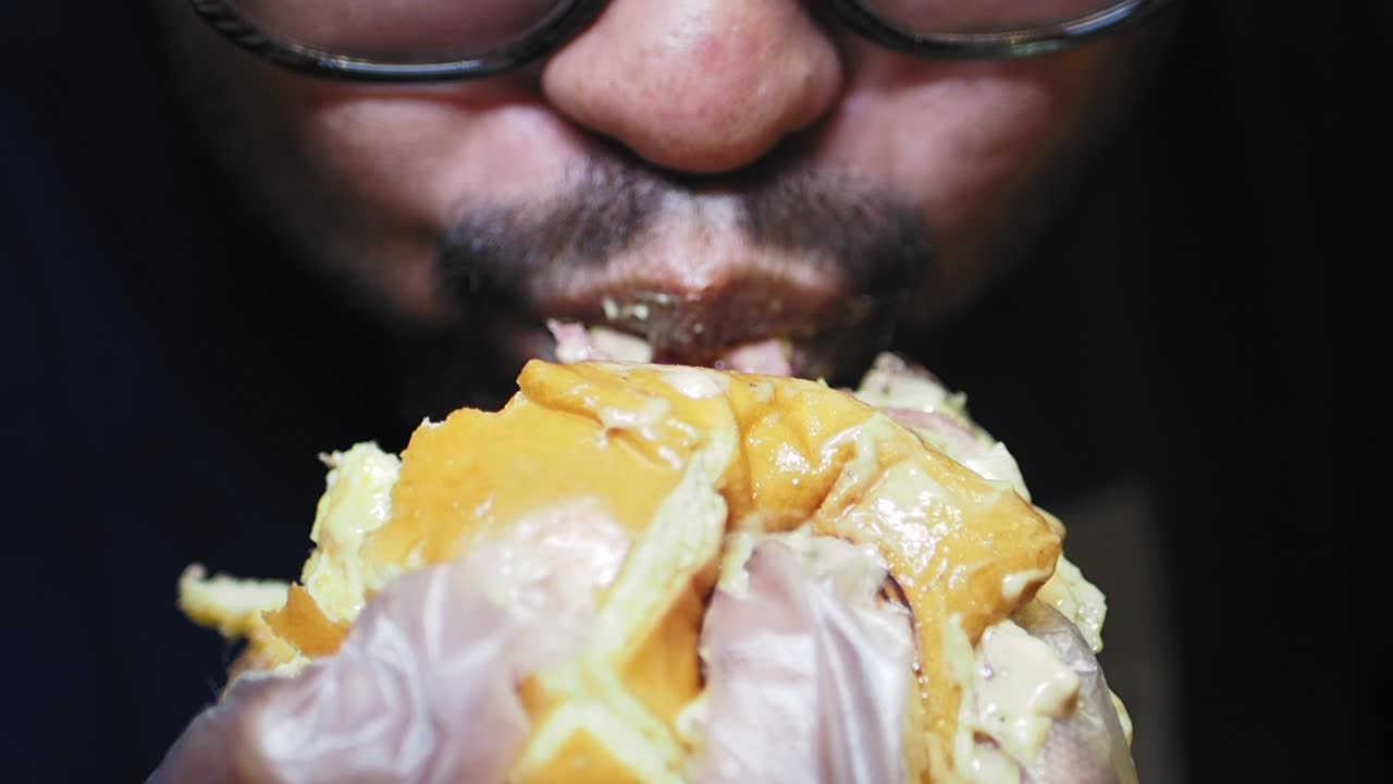 un primer plano de una persona comiendo una hamburguesa