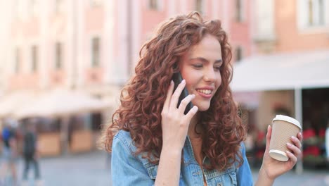 Mujer-Pelirroja-Hablando-Por-Teléfono,-Riendo-Y-Tomando-Café-Para-Ir-A-La-Calle