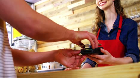 el cliente paga la factura a través de un teléfono inteligente utilizando tecnología nfc