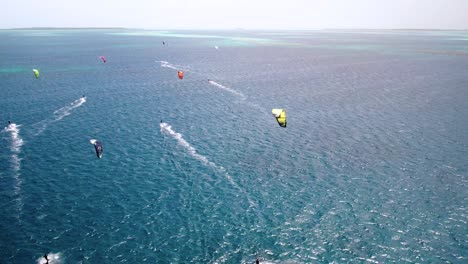 a colorful kite surfer gliding over clear turquoise waters, vibrant and dynamic ocean scene, aerial view