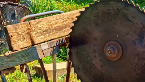 old circular saw stands outdoors on rustic sawhorse setup on sunny day at sawmill