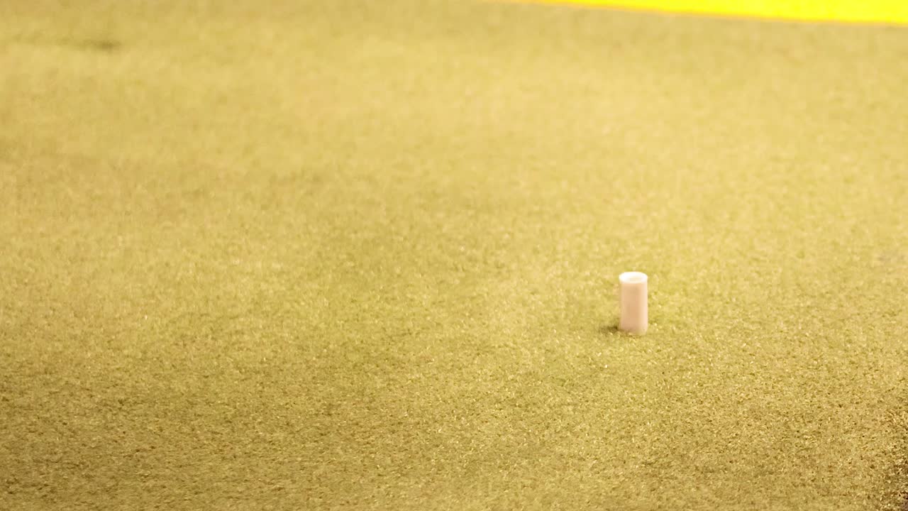 Primo piano di una mazza da golf che oscilla per colpire una palla bianca da un tee