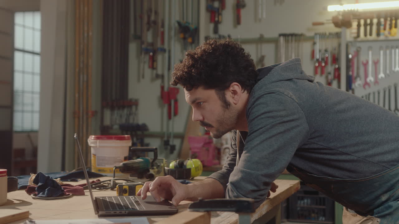 Woodworker Using Laptop in Carpentry Workshop