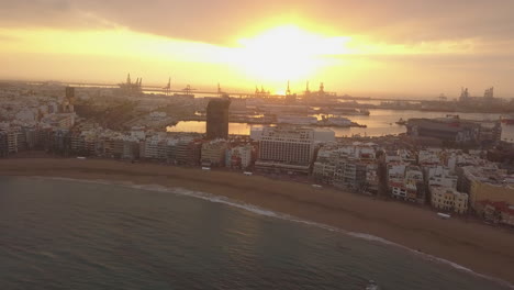 fantastic aerial shot backwards and at sunrise over las canteras beach and where the wonderful colors of sunrise can be seen