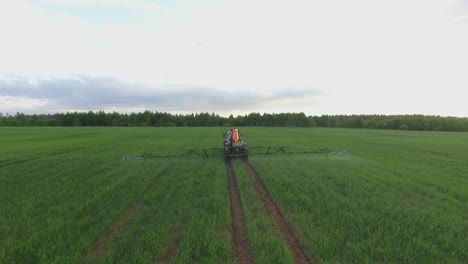 pesticide and fertilizer spraying on the field aerial view with tractor