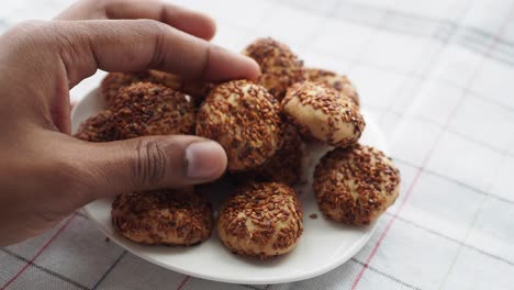 hand reaching for sesame cookies