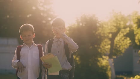 kids in school uniform with bags stand holding books