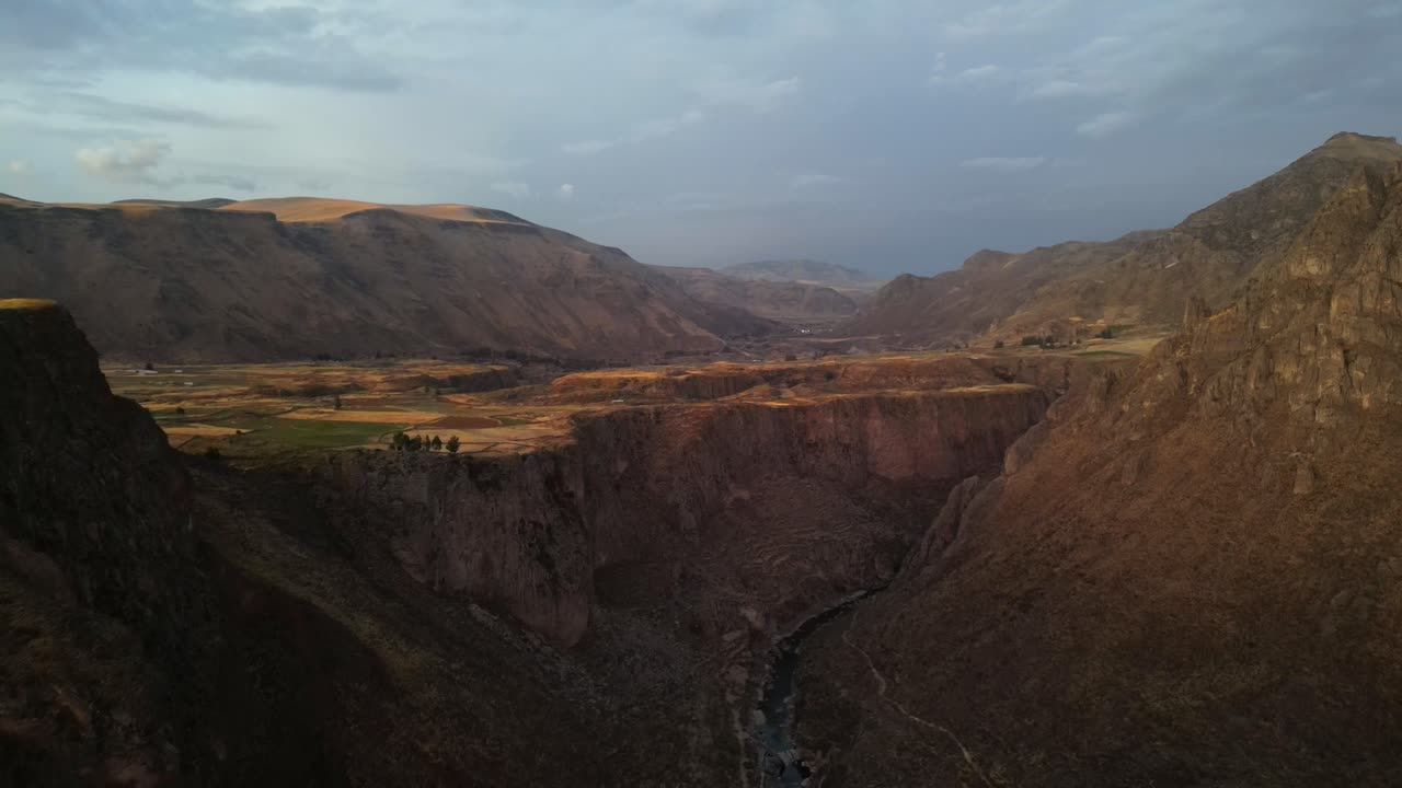 Filmato aereo ad alta quota che mostra il paesaggio andino al crepuscolo, antichi terrazzamenti e creste avvolti nella foschia blu della sera