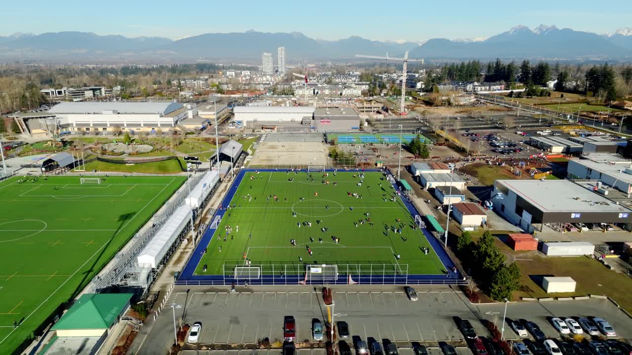 Football Players At Willoughby Community Park Stadium. Langley Events Centre In Langley, BC, Canada. aerial shot, descending approach