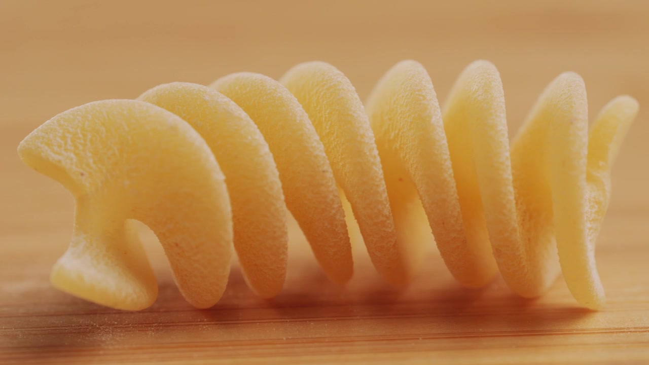 Gros plan de pâtes fusilli crues sur une surface en bois
