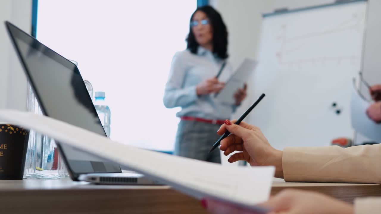 imágenes de una mujer de negocios madura presentando análisis de negocios y estrategia a sus colegas en una pizarra