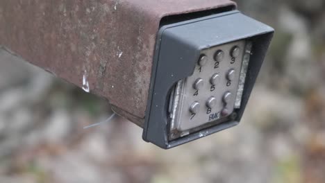 person typing in a code to open a gate using buttons digital input pad