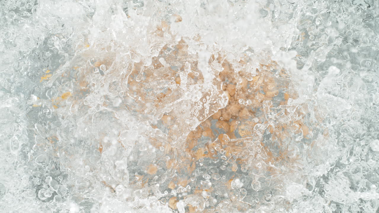 los garbanzos cayendo en una olla de agua hirviendo haciendo un salto en cámara lenta, vista de la mesa