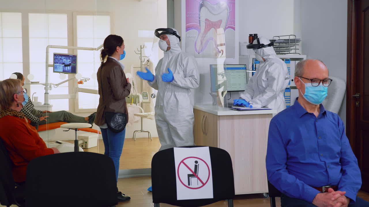 Doctor with overall talking about teeth treatment with patient